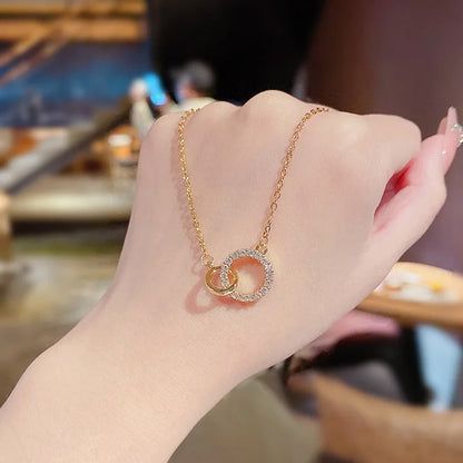 Collana choker in argento sterling 925 con pendente a doppio cerchio in zirconia. - Un dettagliato primo piano della collana choker in argento sterling 925 con pendente a doppio cerchio in zirconia, evidenziando gli anelli d'oro intrecciati con accenti di zirconia scintillanti.