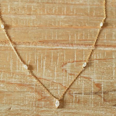 Une vue claire du pendentif en forme de marquise et de la fine chaîne du collier.