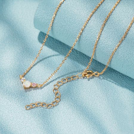 Collar pequeño de ópalo y CZ de plata esterlina 925 - Un primer plano de un collar de plata esterlina 925 con chapado en oro, que presenta un colgante delicado con un ópalo central y piedras de circonita cúbica brillantes.