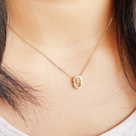 Collar de colgante ovalado hueco de plata esterlina 925 con circonio cúbico al por mayor. - Un primer plano de un collar de colgante ovalado hueco de plata esterlina 925 al por mayor con circonio cúbico, que presenta una delicada cadena de color dorado y un colgante brillante.