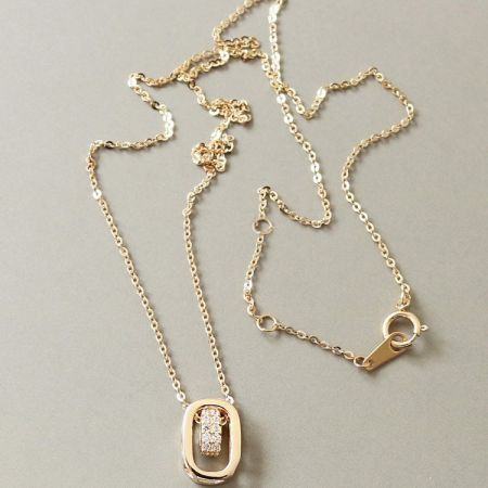 Another perspective of the gold-plated necklace with its intricate oval pendant design.