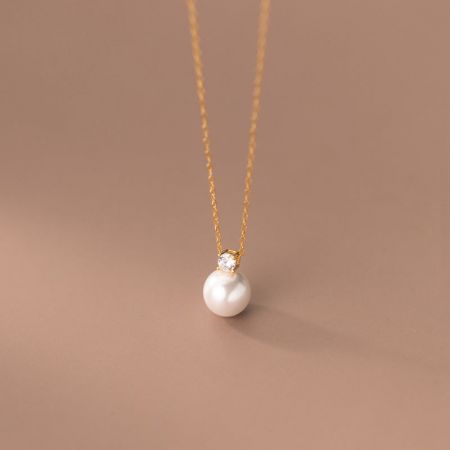 Close-up of the gold-finished pearl and cubic zirconia choker necklace.
