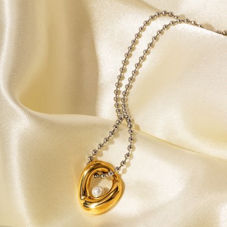 Collar distintivo de oro con un prominente colgante de perla.