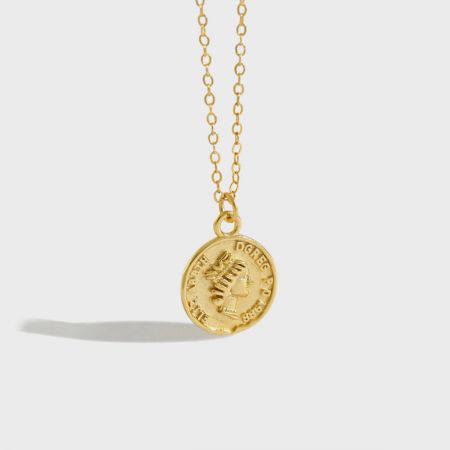 Vue détaillée du pendentif en pièce de monnaie vintage en or présentant un portrait classique et l'année 1886.