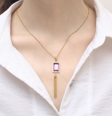 Alternative Farboption, die eine goldene Halskette mit einem rosa Edelsteinanhänger zeigt.