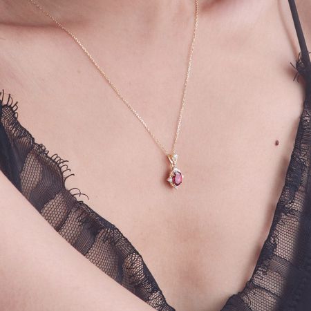 Model wearing the 18K gold vintage ruby pendant necklace to showcase its scale and elegance.