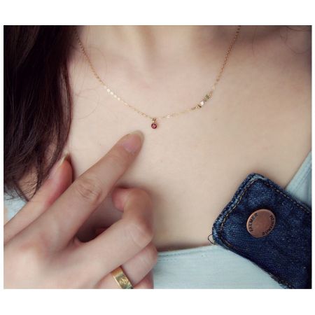 Primer plano del collar con colgante de amor, destacando la vibrante piedra de circonio cúbico roja.