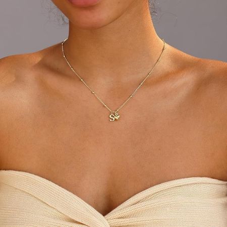 Detailed view of the gold heart necklace with a stylish 'S' initial pendant.