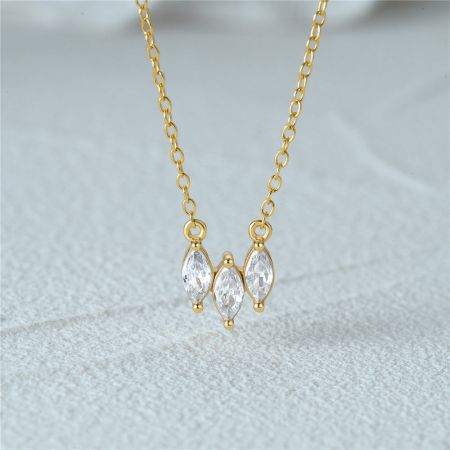 Collar de zirconia microengastada de plata esterlina 925. - Un primer plano del collar de zirconia microengastada de plata esterlina 925, mostrando las tres piedras brillantes en una cadena chapada en oro.