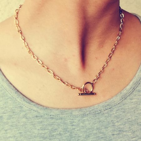 Model wearing the gold toggle pendant necklace to showcase its elegant look.