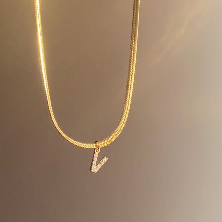 Een verbluffende gouden ketting met de sprankelende 'V' initialenhanger.