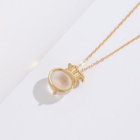 Otro collar del conjunto de bolsa de la suerte, que muestra un colgante circular con una brillante piedra blanca.