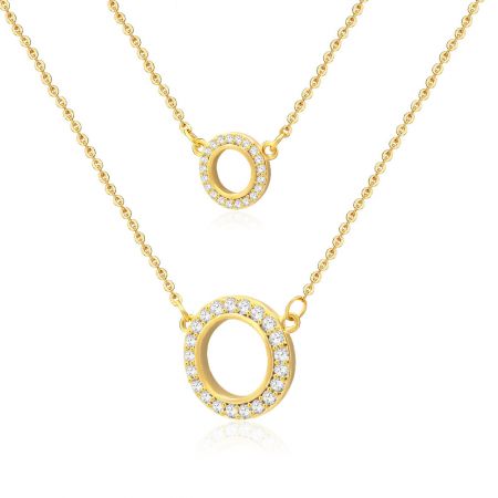 Detailopname van de vergulde dubbele cirkel hangers, met de ingewikkelde zetting van de witte cubic zirconia edelstenen.