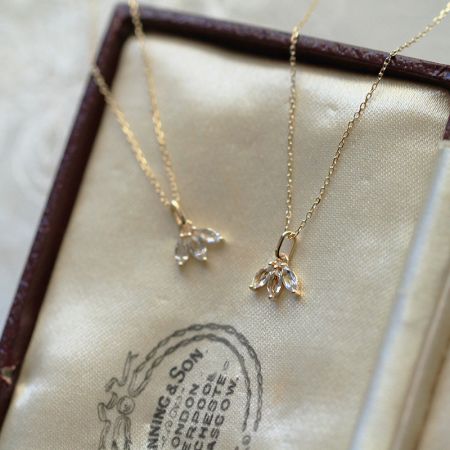 Una colección de dos collares de plata esterlina chapados en oro del conjunto, con brillantes colgantes de cristal.