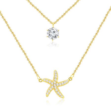 Nahaufnahme der beiden goldenen Halsketten, die den einzelnen großen runden Diamantanhänger und den mit kleineren Diamanten besetzten Seesternanhänger hervorheben.