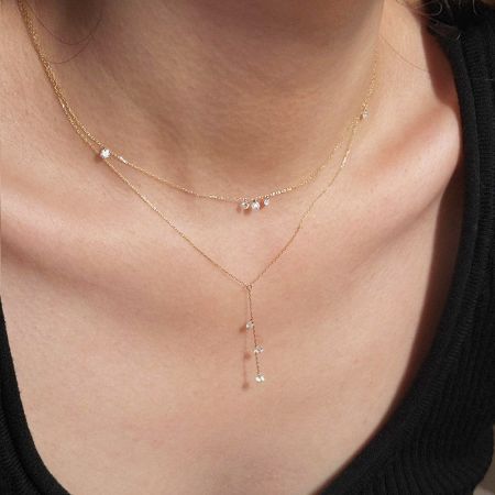 Collar de Zirconia de Plata 925 Chapado en Oro de 18K - Un primer plano de una mujer usando un elegante conjunto de collar de plata esterlina 925 chapado en oro de 18K, con piedras de zirconia cúbica brillantes.