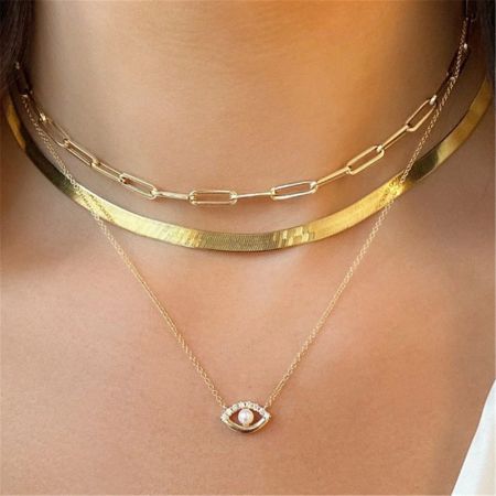 Layered look of the gold evil eye necklace set on a model.
