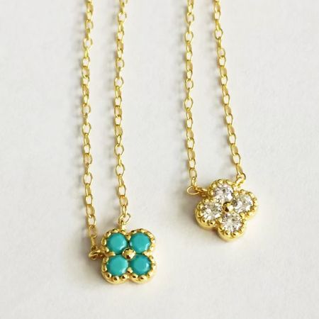 Top-down view of the two gold necklace variations with flower-shaped pendants.