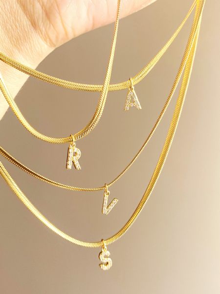 Een mooie weergave van verschillende gouden initialenkettingen uit de collectie.