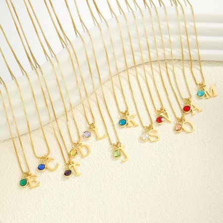 قلائد الأزياء - مجموعة نابضة من قلائد الأزياء الذهبية من JR Fashion Accessories، تتميز بمعلقات حروف متنوعة وأحجار كريمة ملونة.