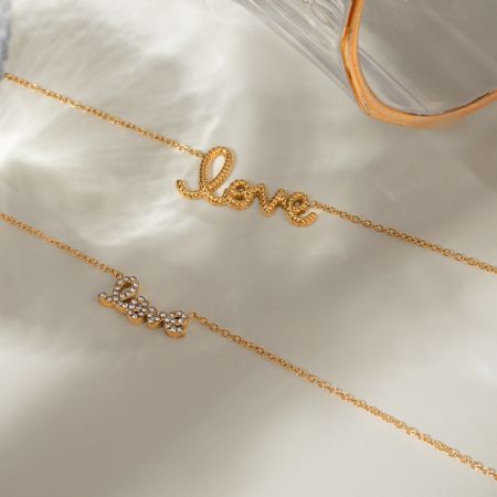 Close-up van de gouden 'Love' ketting om de nek van een model, met de anti-tarnish gouden choker ketting.