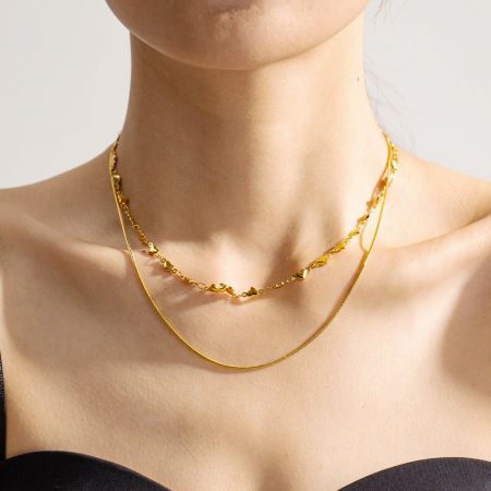 Roestvrijstalen dubbelgelaagde hartkettingen set van 5 - Een close-up van een vrouw die de elegante dubbelgelaagde gouden hartketting draagt, waarbij het delicate ontwerp wordt getoond.