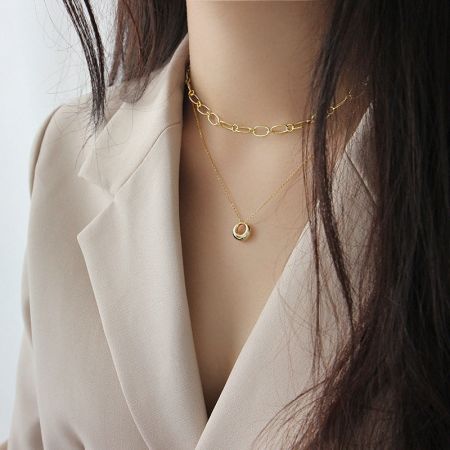 Gros plan du collier en cercle géométrique plaqué or 18K, démontrant son look moderne et stylé.