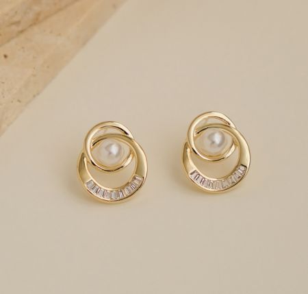 Détail en gros plan des boucles d'oreilles à clou en perles à double anneau, se concentrant sur le sertissage complexe de cristaux et de perles.