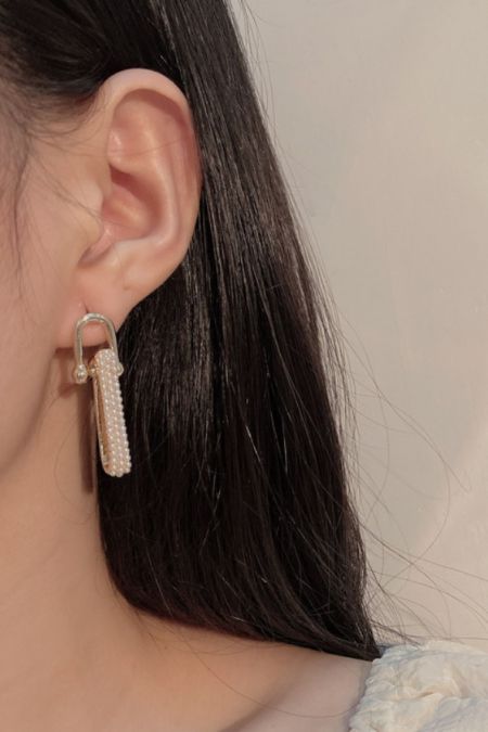 Modèle portant les boucles d'oreilles à pampilles en chaîne de perles pour mettre en valeur leur longueur et leur style.