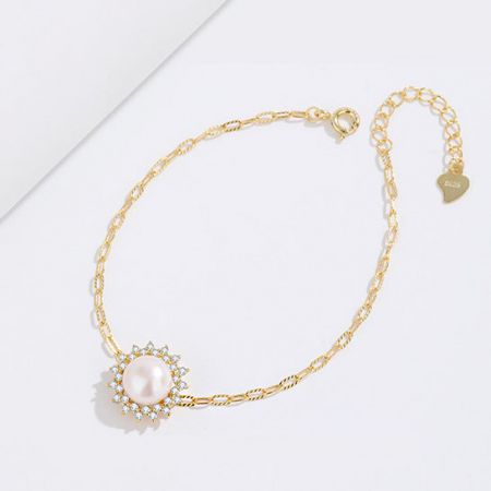 Elegant gold bracelet showcasing the pearl and zircon centerpiece against a neutral background.