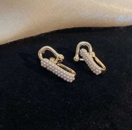 Une vue alternative des boucles d'oreilles à pampilles en chaîne de perles sur fond blanc.