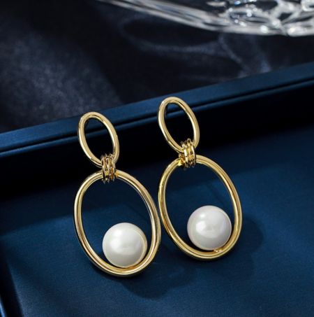 Vue latérale de la bague ovale polie avec des boucles d'oreilles en perles mettant en valeur l'ajustement de la perle blanche.
