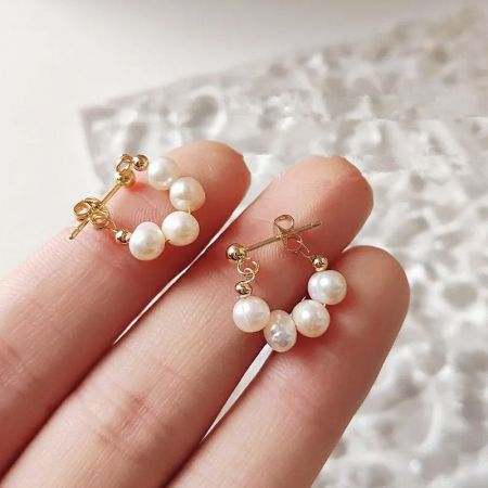 A pair of baroque freshwater pearl earrings with gold hardware, highlighting their natural, irregular shapes.