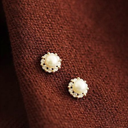 Another design from the set, featuring gold settings with clear stones and pearl centers.