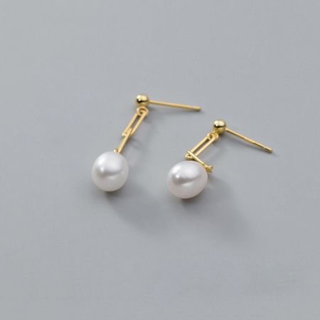 Un'altra prospettiva degli orecchini a goccia vintage in oro e perla, che illustra la loro qualità artigianale.