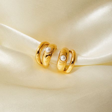 Foto del producto de los aretes de clip con arete de perla de doble capa dorado.