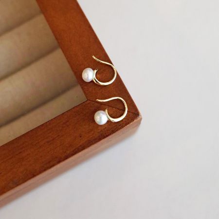 Pendientes colgantes de perla de agua dulce única estilo francés de plata esterlina 925 al por mayor. - Un par de elegantes pendientes colgantes de plata esterlina 925 estilo francés, cada uno con una sola perla de agua dulce lustrosa, exhibidos para venta al por mayor.