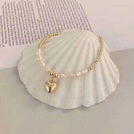 Another angle of the gold and pearl bracelet highlighting the heart pendant.
