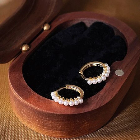14k Gold Plated Pearl Hoop Huggie Earrings - A set of five 14k gold-plated pearl hoop huggie earrings displayed in a black velvet-lined wooden box.