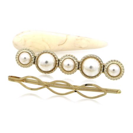 A pearl barrette and a gold hairpin from the collection, highlighting their intricate design.