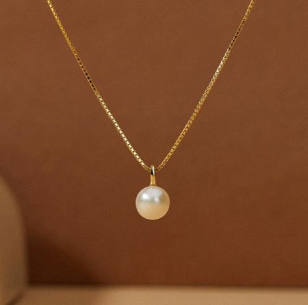 Collar Minimalista de Perlas Chapado en Oro de Plata Esterlina 925 - Un delicado collar de plata esterlina 925 con chapado en oro, que presenta un solo y elegante colgante de perla de agua dulce sobre un fondo blanco.
