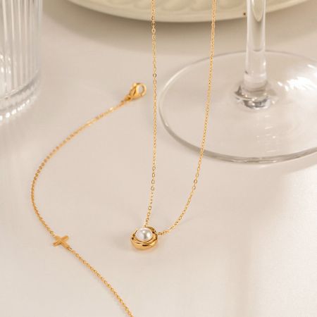 Fullständig vy av guld pärlhängsmycket halsband som visar den delikata kedjan och låset.
