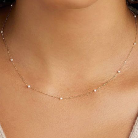 Model wearing the gold pearl chain necklace to showcase its length and style.