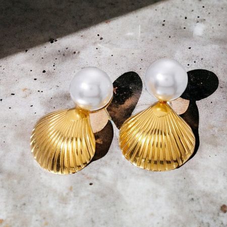 Par de aretes de perla y oro con diseño de concha.