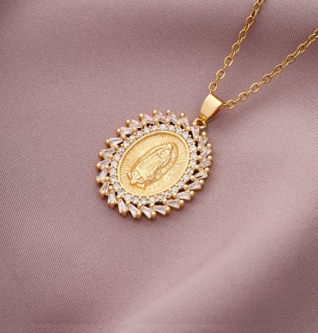 Detaillierte Ansicht einer maßgefertigten goldenen Anhängerkette mit einer gravierten religiösen Figur und umgebenden Edelsteinen.