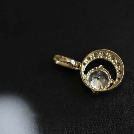 Primo piano del brillante zirconia cubica incastonata nel pendente placcato in oro.
