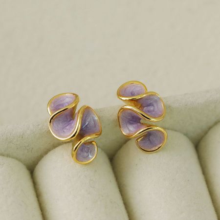 Un par de pendientes de ola de esmalte púrpura con un diseño único de oro en espiral.