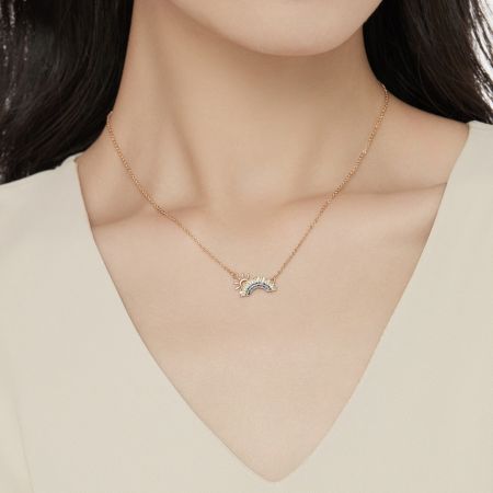 Un modelo que lleva un collar con colgante de arcoíris chapado en oro de 18K, mostrando su aspecto elegante.
