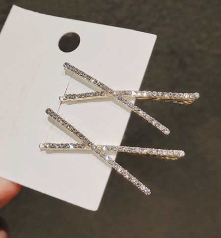 Foto de producto en primer plano de los clips para el cabello Cross Crystal chapados en oro, mostrando los intrincados detalles de strass.