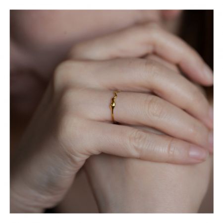 Bague en bande ondulée en argent sterling 925, bague minimaliste en or plaqué 18K en forme de goutte pour femmes - Gros plan d'une bague en bande ondulée minimaliste plaquée or 18K avec un détail en goutte d'eau, portée sur le doigt d'une femme pour mettre en valeur son design élégant.